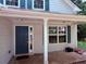 Inviting covered front porch with blue front door and large window at 7250 Bridgeport Ct, Austell, GA 30168