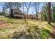 Expansive backyard showing the home's exterior, including the sunroom, with mature trees and a lush lawn at 3937 Locklear Way, Atlanta, GA 30360