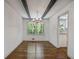 Elegant dining area featuring hardwood floors, modern lighting, and views of a garden through a large window at 3937 Locklear Way, Atlanta, GA 30360