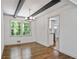 Bright dining room featuring wood floors, beamed ceiling, chandelier and large window with view at 3937 Locklear Way, Atlanta, GA 30360