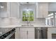 Modern kitchen features a stainless steel dishwasher, bright backsplash, and views of the lush green outdoors at 3937 Locklear Way, Atlanta, GA 30360