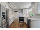 Modern kitchen boasts white cabinets, stainless appliances, patterned tile, and wood floors at 3937 Locklear Way, Atlanta, GA 30360