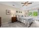 Cozy bedroom featuring tray ceilings, a ceiling fan, neutral colors, and a large window with natural light at 4967 Jett Rd, Marietta, GA 30066