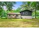 Charming single-Gathering home featuring a mix of siding, a wooden deck, and a backyard with large shade trees at 586 Chris Cir, Lawrenceville, GA 30044