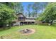 Expansive backyard with a large deck, fire pit, and lush green lawn at 6230 S Summers S Cir, Douglasville, GA 30135