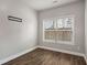 Bright bedroom featuring wood floors, window, natural light, and a wall-mounted TV bracket at 829 Overlook Path Ln, Lawrenceville, GA 30045