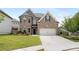 Attractive two-story home with a brick facade, a well-maintained lawn, and a double garage at 829 Overlook Path Ln, Lawrenceville, GA 30045