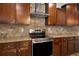 Gourmet kitchen featuring stainless steel appliances, tile backsplash, and wooden cabinets at 829 Overlook Path Ln, Lawrenceville, GA 30045