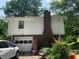 A charming home exterior with a brick base and white siding, featuring a garage and well-maintained yard at 2505 King Louis Rd, Conyers, GA 30012