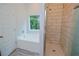 Modern bathroom features a shower with white subway tile and a bathtub under the window at 275 Green Commons Dr, Covington, GA 30016
