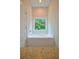 Bright bathroom features a modern tub under the window and a tile floor at 275 Green Commons Dr, Covington, GA 30016