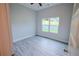 Bright bedroom features wood floors, neutral walls, and a large window with verdant outdoor views at 275 Green Commons Dr, Covington, GA 30016
