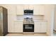 Well-lit kitchen featuring stainless steel appliances, sleek white cabinetry, and light countertops at 275 Green Commons Dr, Covington, GA 30016