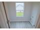 Bright laundry room with hardwood floors and a window overlooking the backyard at 275 Green Commons Dr, Covington, GA 30016