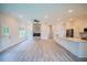 Open-concept living room boasts a stone fireplace and hardwood floors adjacent to the modern kitchen at 275 Green Commons Dr, Covington, GA 30016