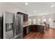 Open kitchen boasts stainless steel appliances, granite counters, and hardwood floors, flowing into the breakfast area at 403 Sonja Ln, Loganville, GA 30052