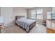 Neutral bedroom with a wood and metal bed frame, natural light, and carpeted floors at , Loganville, GA 30052
