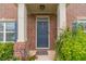 Stylish front entrance featuring a blue door, brick facade, 'Welcome' mat, and decorative plants at , Loganville, GA 30052