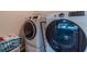 Modern laundry room featuring front-loading washer and dryer with laundry basket, offering convenience at , Loganville, GA 30052