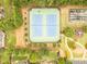 Aerial view of community tennis courts, playground, and basketball court surrounded by lush trees and green grass at 2059 Ivey Chase Dr, Dacula, GA 30019