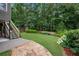 Manicured backyard featuring a stone patio, tiered landscaping, and steps to upper deck at 2059 Ivey Chase Dr, Dacula, GA 30019