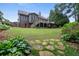 Exterior view of the home featuring a large backyard, deck, and lush landscaping at 2059 Ivey Chase Dr, Dacula, GA 30019
