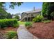 Landscape view of the backyard showing stone path leading to a two story home with deck at 2059 Ivey Chase Dr, Dacula, GA 30019