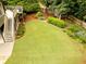 Backyard with a lush lawn, deck, wooden shed, and landscaped garden at 2059 Ivey Chase Dr, Dacula, GA 30019