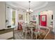 Charming dining area featuring a round table, bright windows, and a welcoming red front door at 2059 Ivey Chase Dr, Dacula, GA 30019