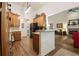 Open kitchen with wood cabinets, granite countertops, and view of the living room fireplace at 2059 Ivey Chase Dr, Dacula, GA 30019