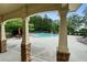 View of the community pool with a covered area with columns and stone accents and several lounge chairs and tables at 2059 Ivey Chase Dr, Dacula, GA 30019