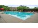 Community pool with clear blue water and several lounge chairs and tables and a covered structure to the rear at 2059 Ivey Chase Dr, Dacula, GA 30019
