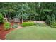 Backyard storage shed with double doors, pathway, and professional landscaping at 2059 Ivey Chase Dr, Dacula, GA 30019
