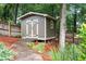 Backyard storage shed featuring board and batten siding with a stone path at 2059 Ivey Chase Dr, Dacula, GA 30019