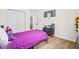Calming bedroom with a purple bedspread, stylish black dresser, light-toned wood flooring, and ample closet space at 4430 Lamar Dr, Douglasville, GA 30134