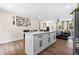 Modern kitchen boasts a spacious island with white cabinets, complemented by sleek hardware and an open layout to the living area at 4430 Lamar Dr, Douglasville, GA 30134