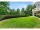 Expansive green backyard featuring a manicured lawn, trimmed hedges, and views of the home's exterior at 4720 Cliffside Ct, Marietta, GA 30067