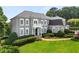 Elegant home featuring a manicured lawn, decorative shrubbery, and a classic façade with a small balcony at 4720 Cliffside Ct, Marietta, GA 30067