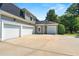 Exterior view of a home with multiple garage doors, landscaping, and a paved driveway at 4720 Cliffside Ct, Marietta, GA 30067