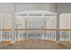 Hallway featuring hardwood railing with wrought iron, view to a living room, and white pillars at 4720 Cliffside Ct, Marietta, GA 30067