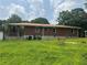 Brick home featuring basement windows, a bench, and a covered outdoor space at 547 Morningside Dr, Lawrenceville, GA 30043