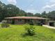 Quaint brick home featuring large front yard, small shrubs, and a covered carport with a small building nearby at 547 Morningside Dr, Lawrenceville, GA 30043