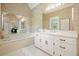Relaxing bathroom with tub, vanity, large mirror, and unique wallpaper at 921 Laurel Crest Dr, Woodstock, GA 30189