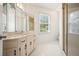 Bright bathroom featuring a large vanity, a window and a glass-enclosed shower at 921 Laurel Crest Dr, Woodstock, GA 30189