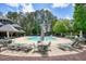 Relaxing community pool surrounded by tall trees with lounge chairs and umbrellas at 921 Laurel Crest Dr, Woodstock, GA 30189