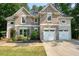 Charming two-story brick home with a manicured lawn and a two-car garage at 921 Laurel Crest Dr, Woodstock, GA 30189