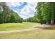 Scenic golf course with lush green fairway surrounded by tall trees creates a serene and inviting atmosphere at 921 Laurel Crest Dr, Woodstock, GA 30189