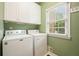 Functional laundry room with a window and appliances in a well-lit space at 921 Laurel Crest Dr, Woodstock, GA 30189