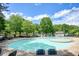 A large community pool is surrounded by tables and chairs for residents to enjoy on a sunny day at 921 Laurel Crest Dr, Woodstock, GA 30189