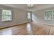 Sunlit bedroom with hardwood floors, large windows, and modern ceiling fan at 1758 N Springs Dr, Atlanta, GA 30338